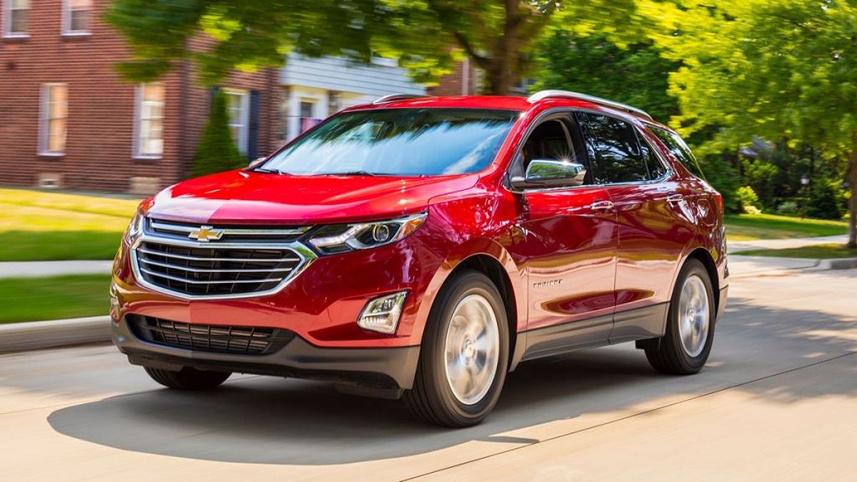 A red 2018 Chevrolet Equinox driving down a city street